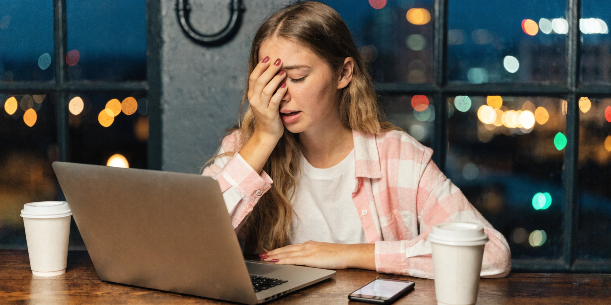 A girl is distressed by online sexual harassment in front of her computer screen.